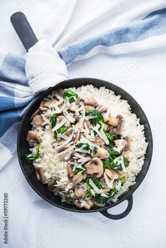 Rice  risotto  with mushrooms  parmesan and spinach top view on white background. Italian cuisine.
