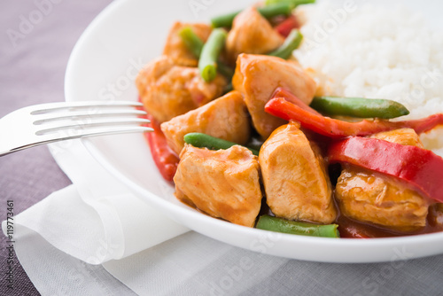 Spicy chicken with vegetables ( green beans and red pepper) and rice. Oriental food.