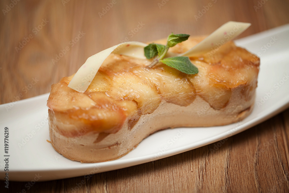 Apple pie with mint on a white plate on a wooden background Apple pie with mint on a white plate on a wooden background