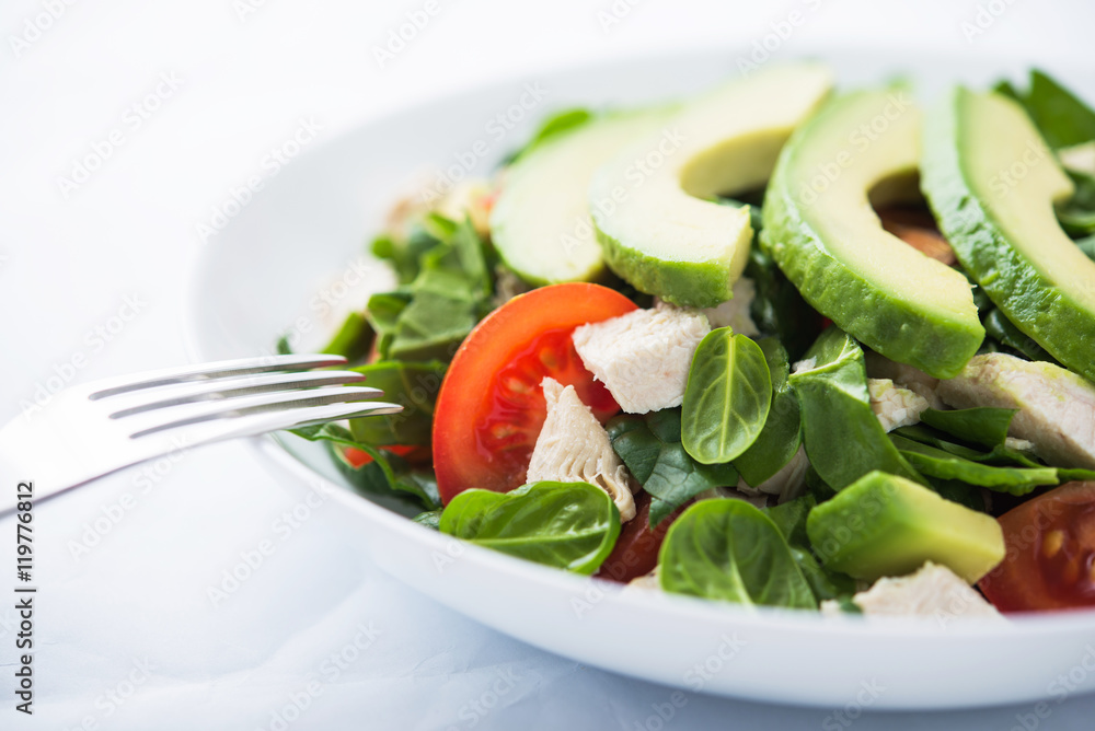 Fresh salad with chicken, tomatoes, spinach and avocado on white background close up. Healthy food. Fresh salad with chicken, tomatoes, spinach and avocado on white background close up. Healthy food.