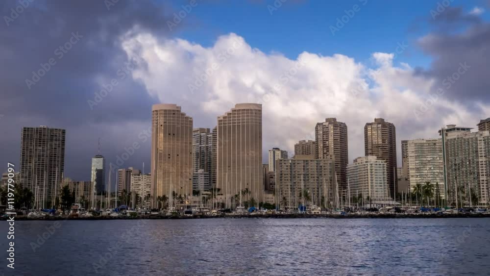 Skyline of Waikiki in the evening with clouds rolling in. Hawaiian canoes visible. Skyline of Waikiki in the evening with clouds rolling in. Hawaiian canoes visible.