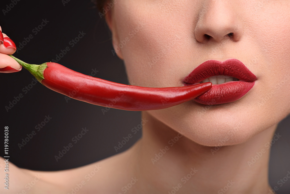 Obraz premium Passionate girl playing with hot pepper
