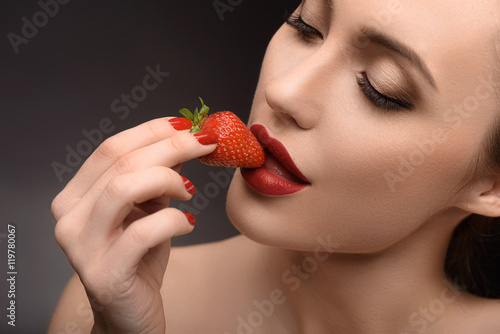 Voluptuous girl eating red berry