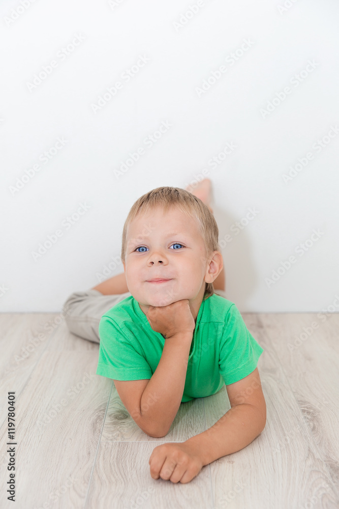 Little handsome boy with blue eyes lying on the floor Little handsome boy with blue eyes lying on the floor