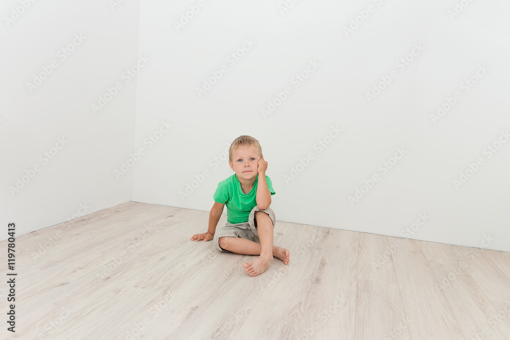 Little cute boy sitting on the floor