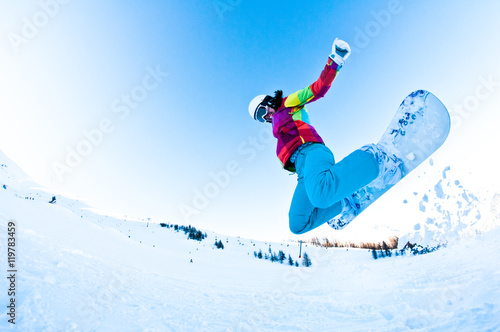 girl snowboarder having great fun jumping