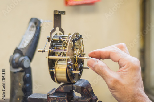 man fixing an old clock mechanism