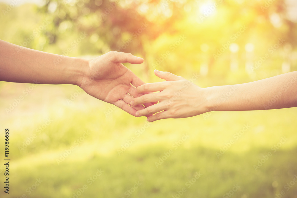 Close up on a man and a woman holding hands at green background,Hand help and hope concept,helping hand Close up on a man and a woman holding hands at green background,Hand help and hope concept,helping hand