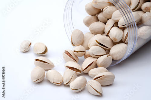 Roasted and salted pistachios in shell on white background