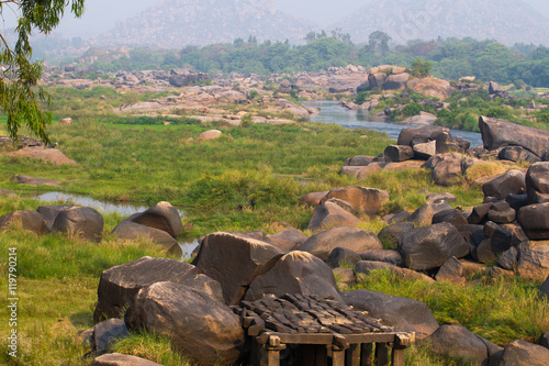 Hampi village Tungabhadra river meadow. Landscape with water, palm, rock, stones. India, Karnataka photo