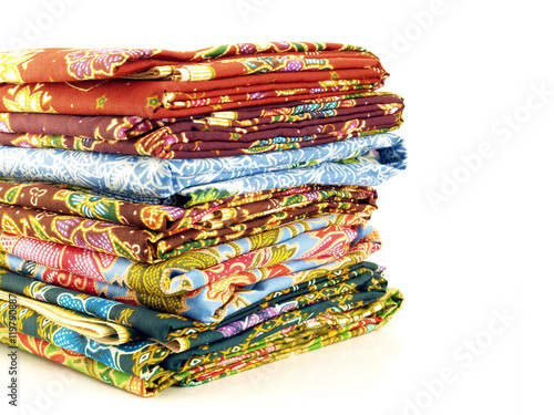Konstfotografi stack of colorful native thai fabric (sarong) isolated on white background, pile