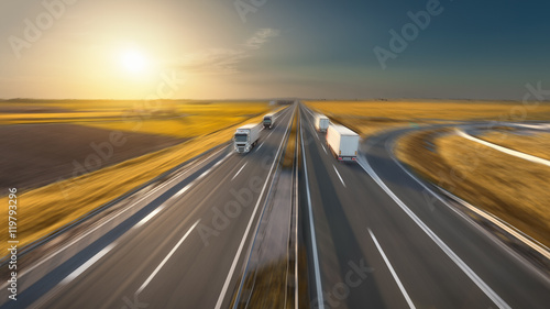 Speed concept with trucks on the highway at idyllic sunset © rasica
