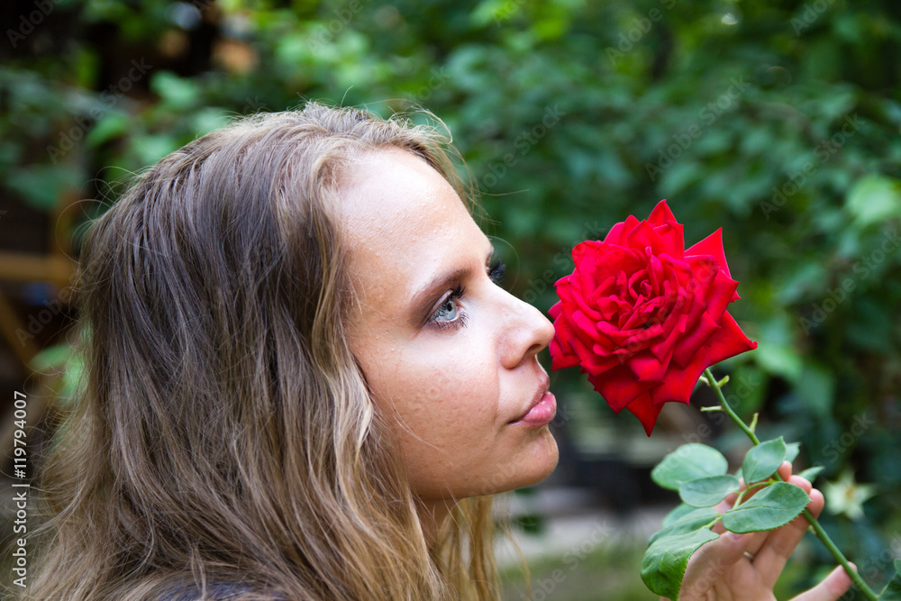 Fototapeta premium Portrait of a beautiful girl with a red rose