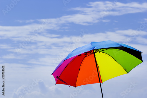 Beautiful Rainbow umbrella on bright sky background.