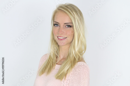 Fotografie Belle fille blonde portant un pull rose