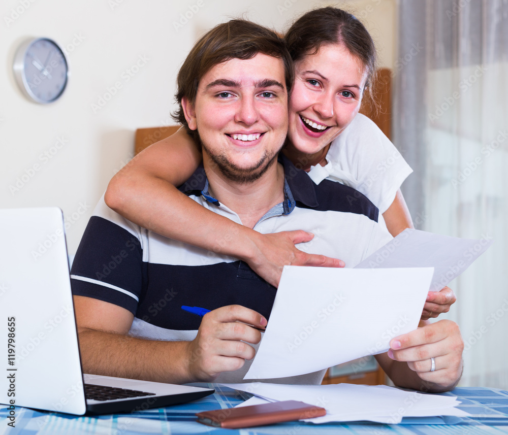 family couple sitting at desk with documents indoors