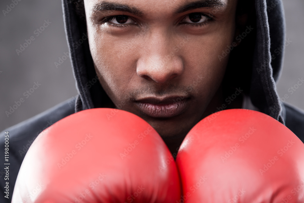 Concentrated African American man with boxing gloves Concentrated African American man with boxing gloves