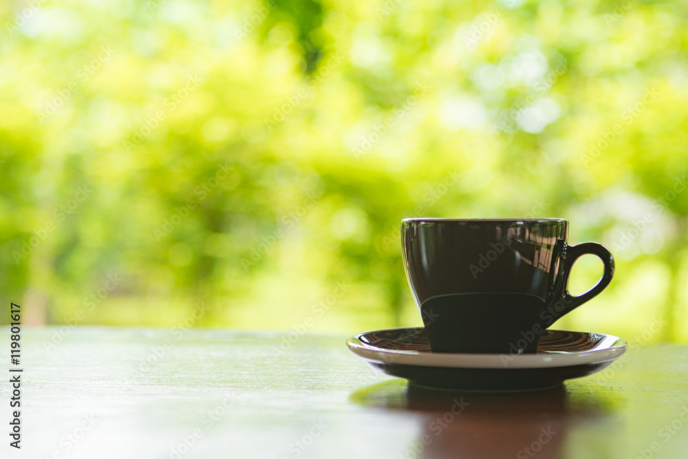 A black cup of coffee on table in cafe ,Morning light A black cup of coffee on table in cafe ,Morning light