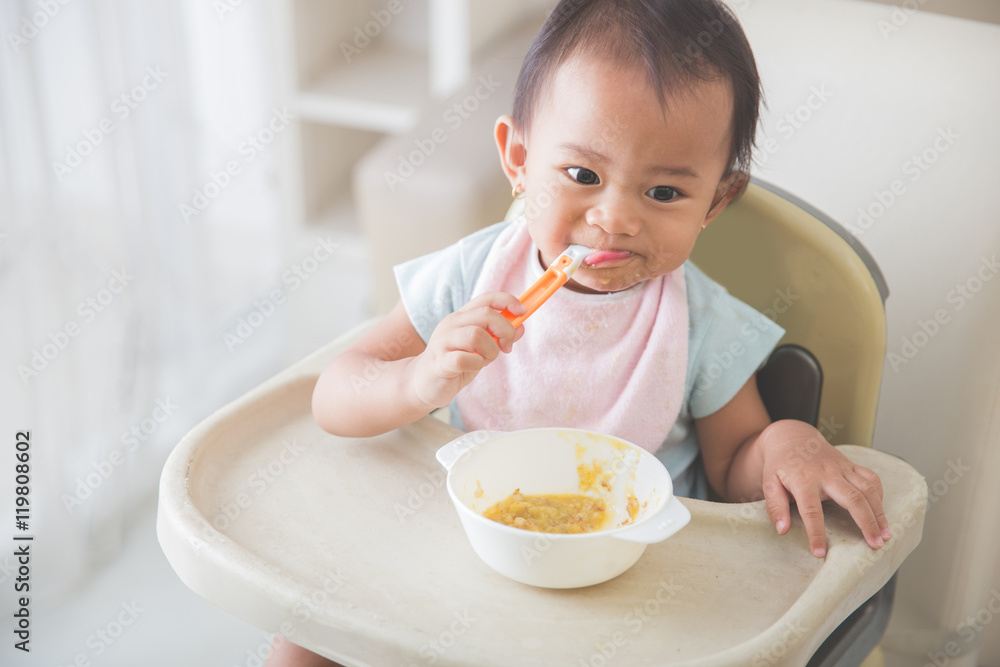 baby girl sitting on high chair and feed her self baby girl sitting on high chair and feed her self