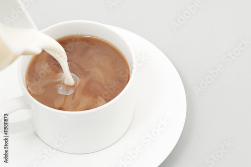 Pouring milk into a cup of coffee