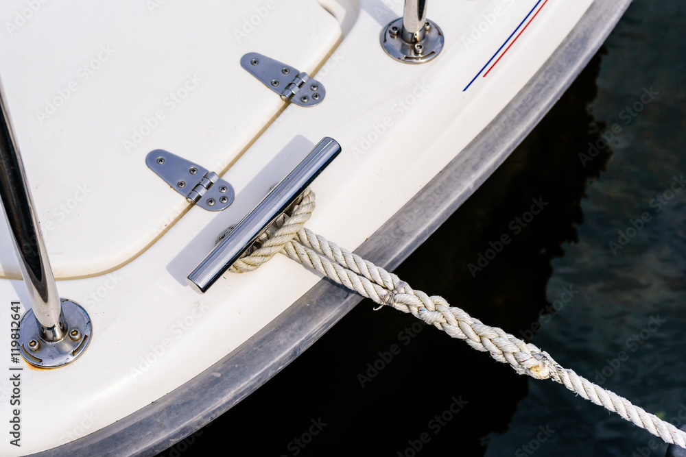 Tight rope attached to boat moored at marina.