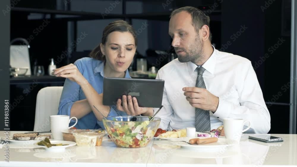 Young businesspeople sitting with tablet and talking during breakfast
Young businesspeople sitting with tablet and talking during breakfast