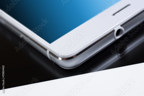 White Business Smartphone With Blue Reflection On White Tablet