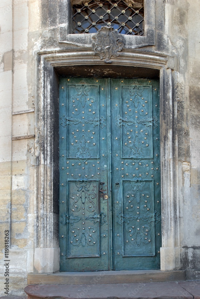 Old blue metal forged door in a stone building