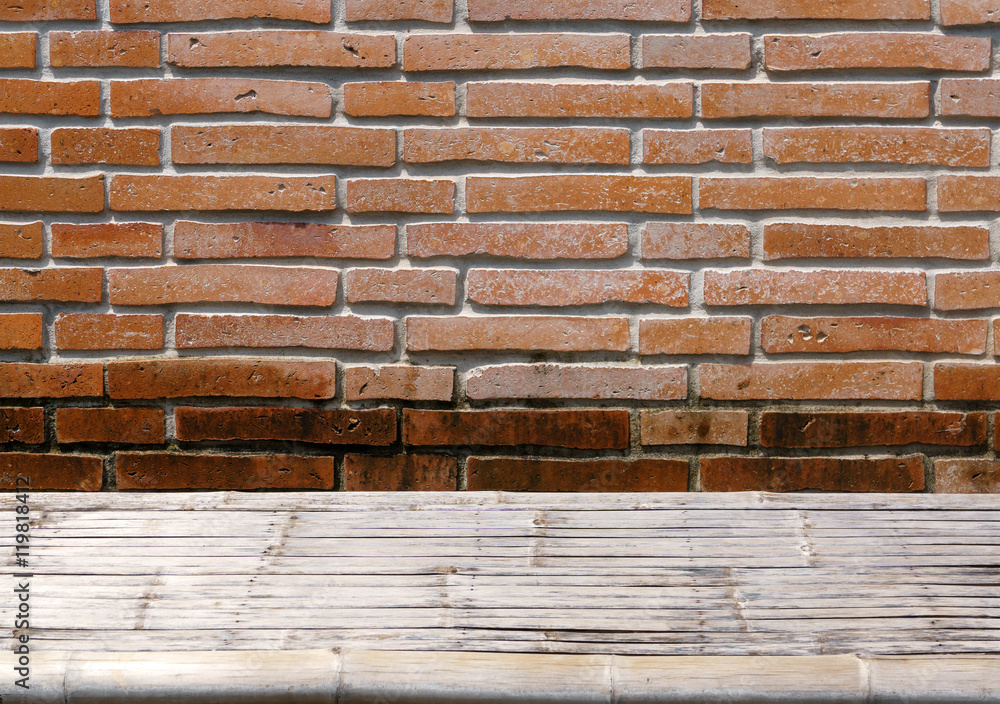 Bamboo wicker table on grunge orange brick wall Bamboo wicker table on grunge orange brick wall