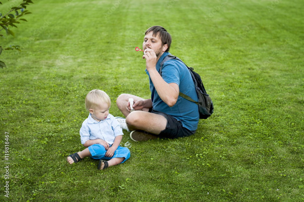 father shows his son how to blow soap bubbles