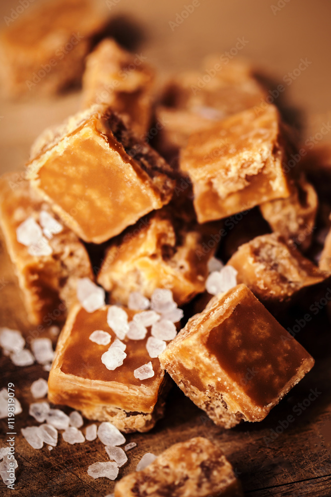 Caramel candies on brown background. Salted caramel pieces and s Caramel candies on brown background. Salted caramel pieces and s