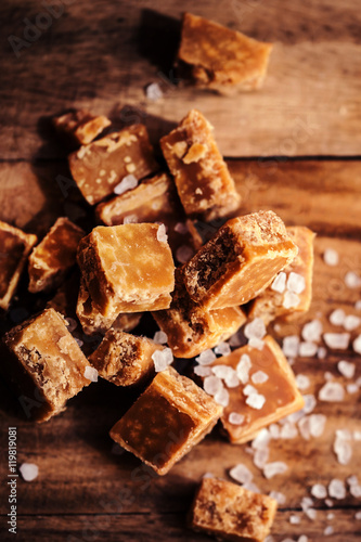 Caramel candies on brown background. Salted caramel pieces and s © nataliazakharova