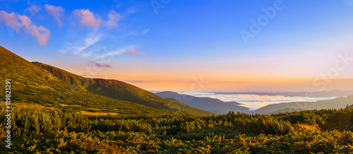Picturesque sunrise morning in mountains above clouds, Carpathians, panoramic view, Ukraine.