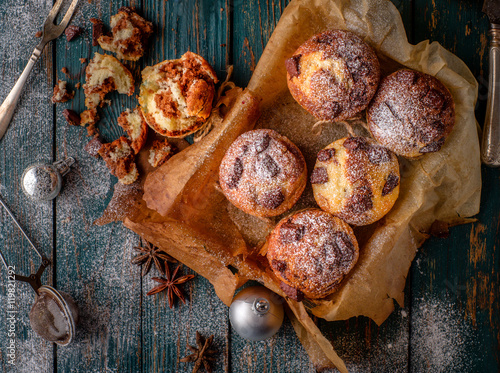 Chocolate muffins with powdered sugar on the wooden table, rusti