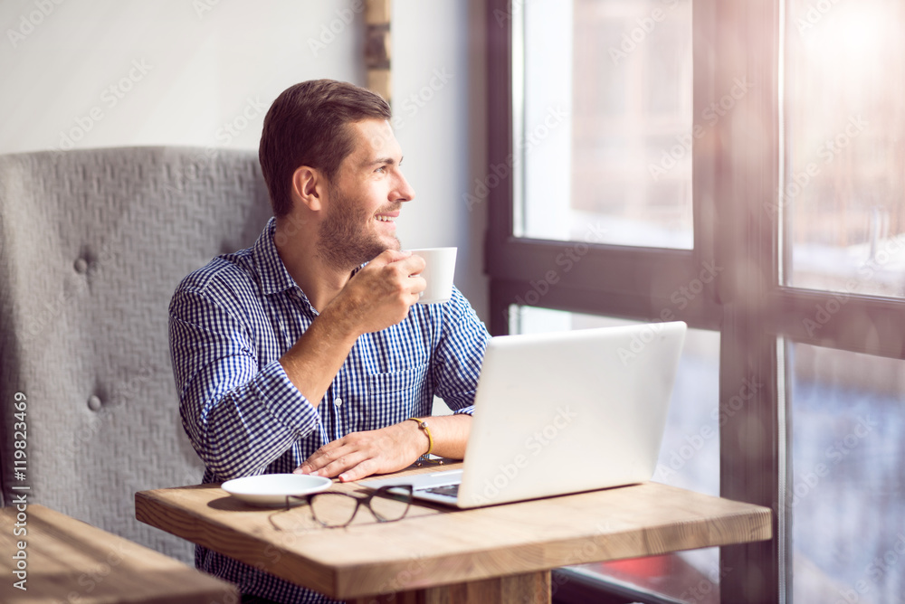 Positive handsome man sitting in the cafe