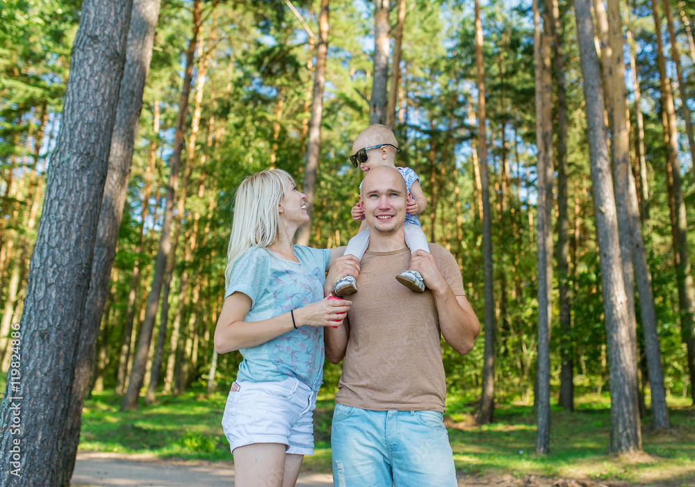 Blonde woman with husband posing in the city park, family portrait Blonde woman with husband posing in the city park, family portrait