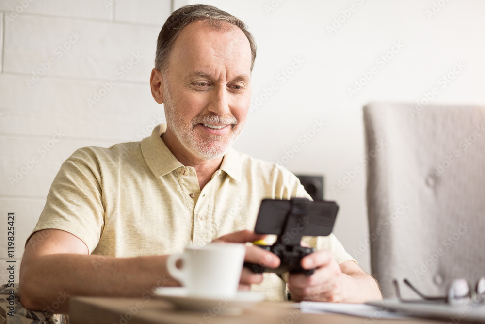 Joyful senior man sitting at the table Joyful senior man sitting at the table