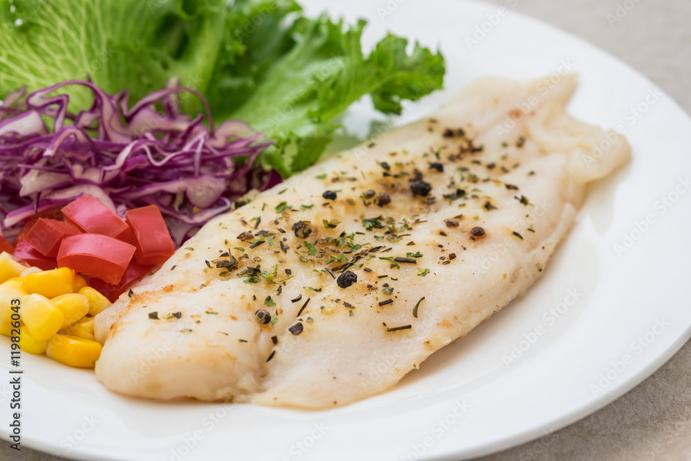 Grilled fish fillet steak with herb and vegetables on plate Grilled fish fillet steak with herb and vegetables on plate