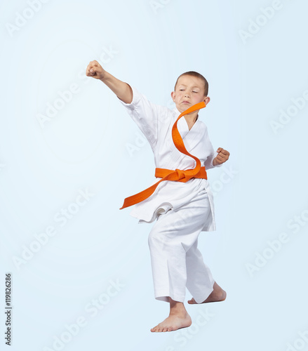 Karateka boy in karategi beats punch arm