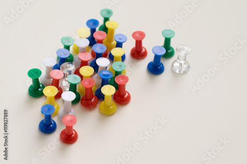 Closeup of colorful pushpin on cream background.