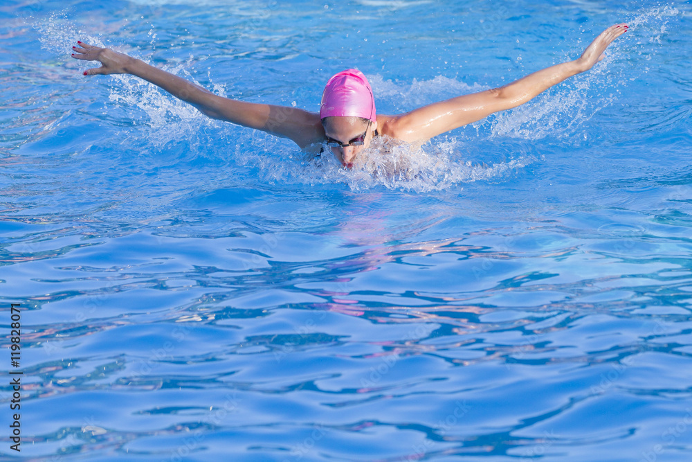 mujer nadando al estilo mariposa en una piscina