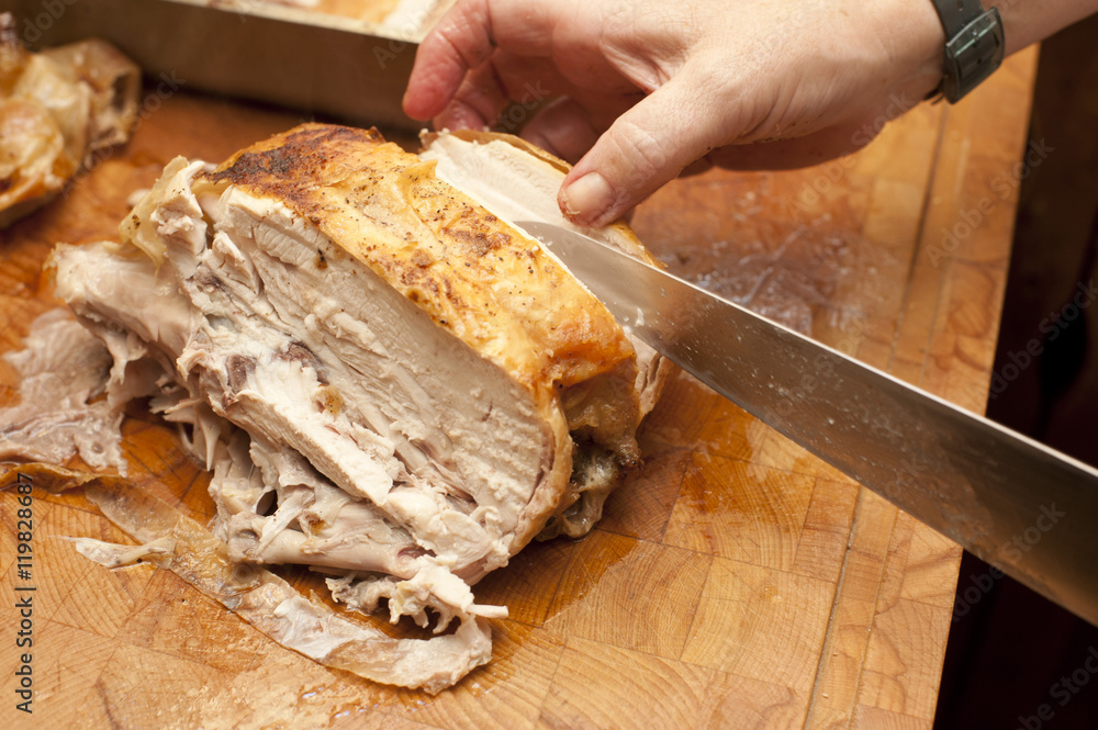 Man carving a half roast chicken Man carving a half roast chicken