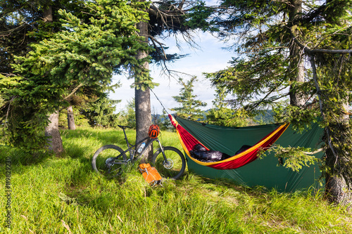 Bike travel and camping with hammock in summer woods