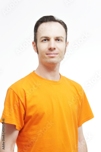 Attractive man wearing T-shirt close up portrait on white background. Close-up portrait of attractive guy . Over white background. Attractive guy in an orange T-shirt.