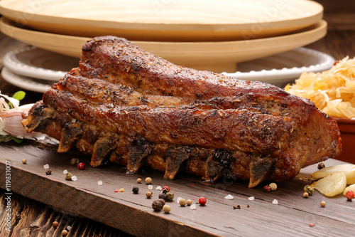 Fried pork ribs with herbs on wooden background