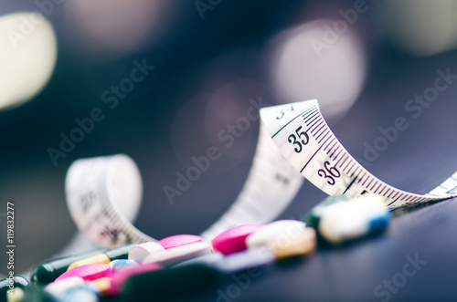 Pharmacy background on a black table with measuring tape. Tablets on a black background. Pills. Medicine and healthy. Close up of capsules. Differend kind of pills 