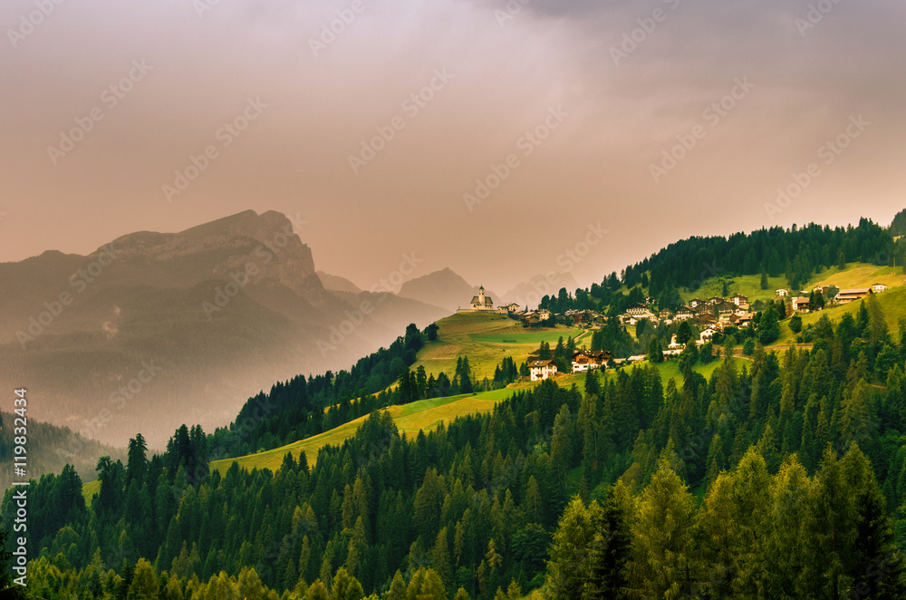 Naklejka premium An alpine village in front of a Dolomites Group, Tyrol, Italy, Europe.