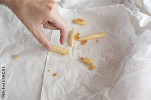 Man eating takeaway French fries photo