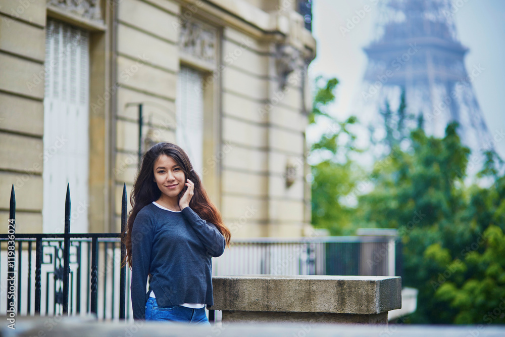 Happy young woman in front of the Eiffel tower Happy young woman in front of the Eiffel tower
