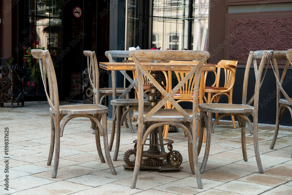 Empty tables and chairs on street cafe